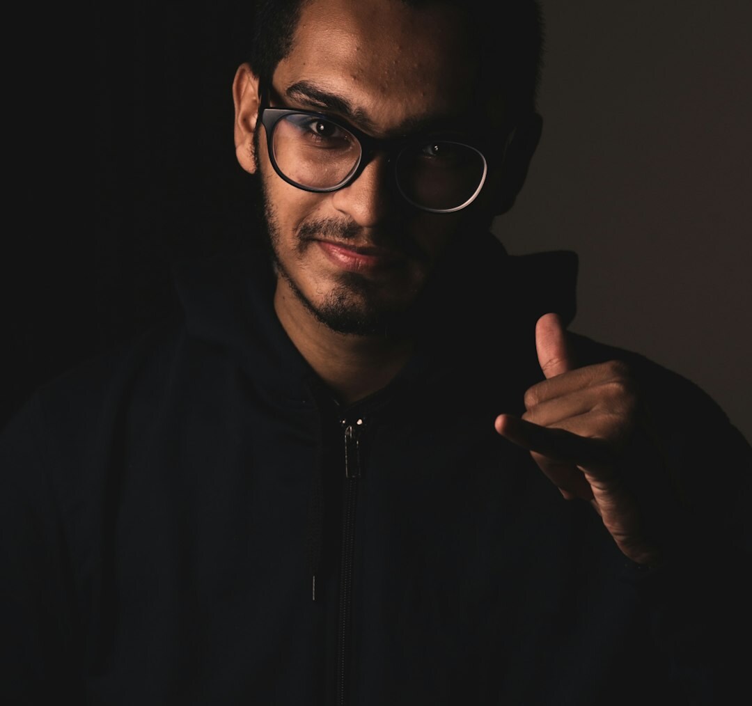 Male technology analyst wearing glasses with a confident expression
